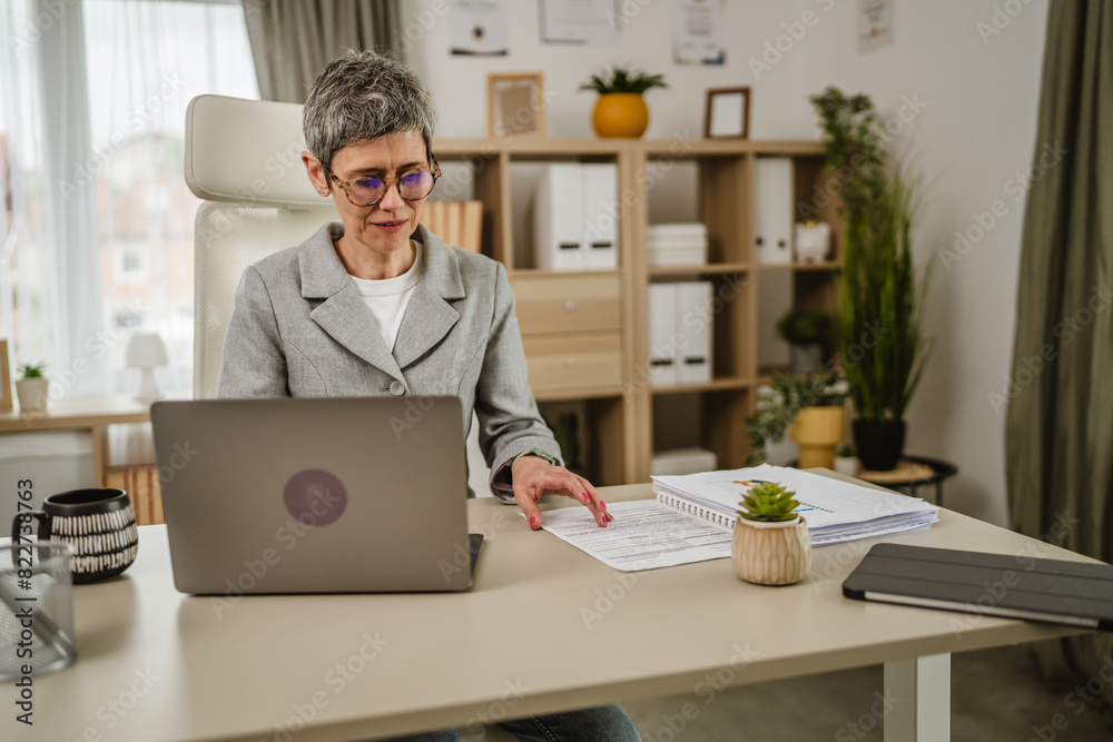 One mature caucasian businesswoman work on laptop at office One mature caucasian businesswoman work on laptop at office