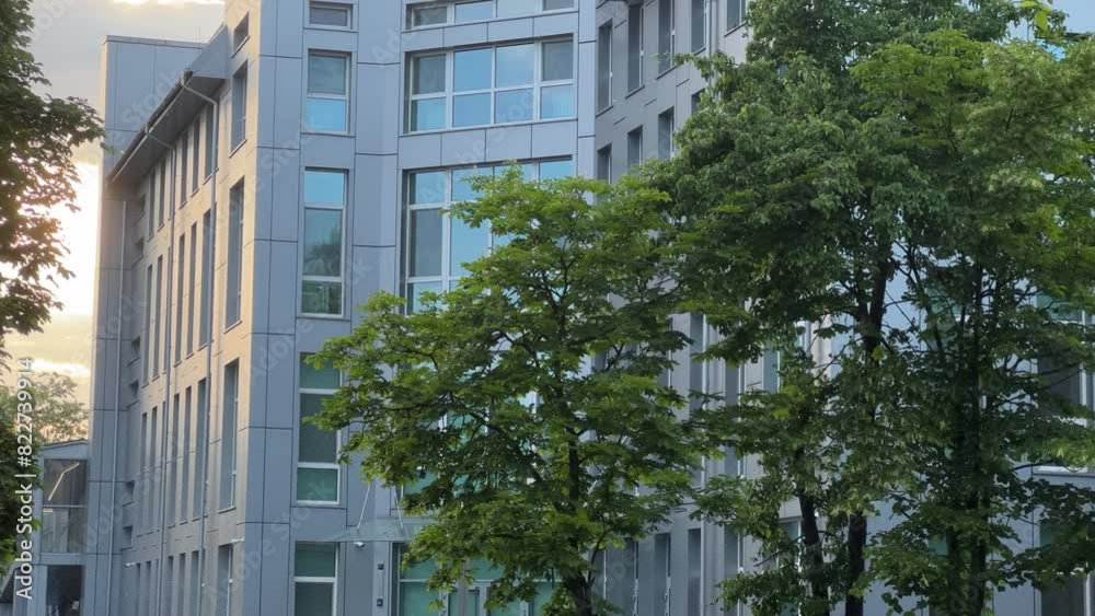 Expansive Modern Factory Office Building with Metal Cladding Glowing in Radiant Sunset Hues Among Dense Greenery Expansive Modern Factory Office Building with Metal Cladding Glowing in Radiant Sunset Hues Among Dense Greenery