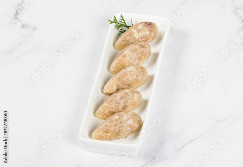 Cold appetizer. Chicken jellied meat in the shape of a quenelle. On a plate. Close up