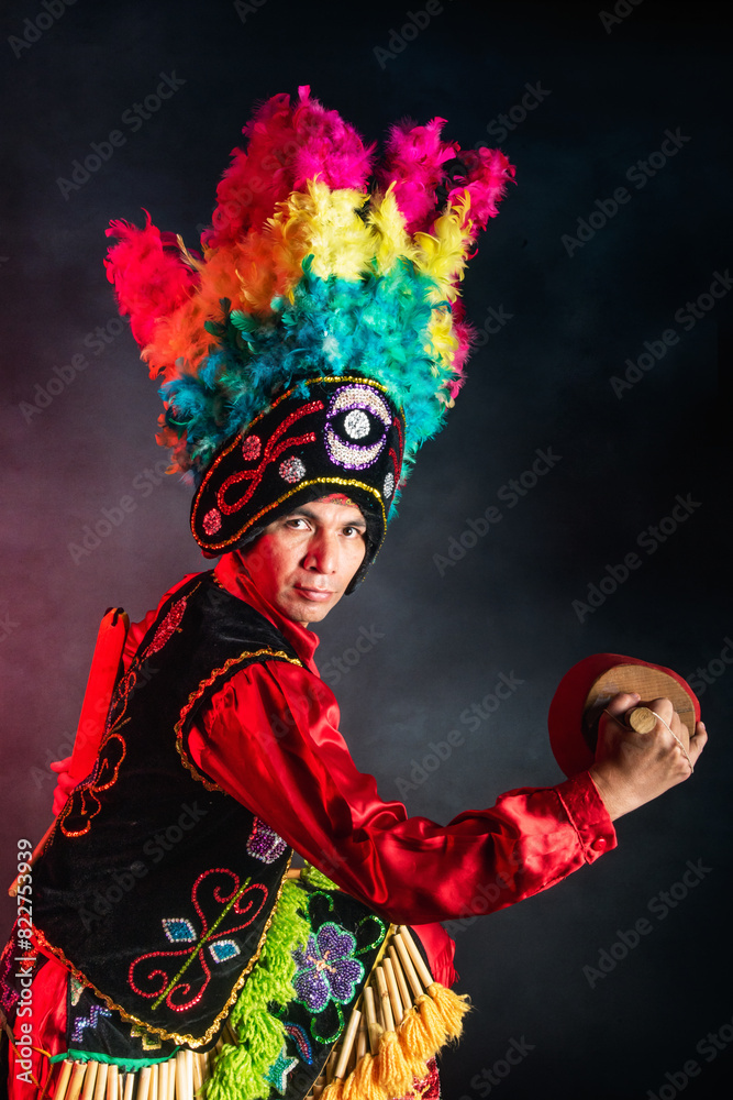 Matlachines Dancer from Coahuila Mexico A man wearing a colorful headdress and a red shirt is holding a drum