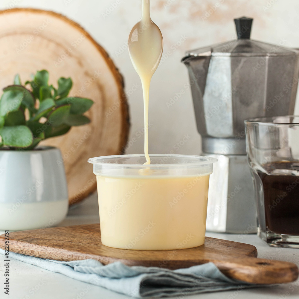 Condensed milk pouring from a spoon, perfect for desserts and sweetening beverages. Condensed milk pouring from a spoon, perfect for desserts and sweetening beverages.