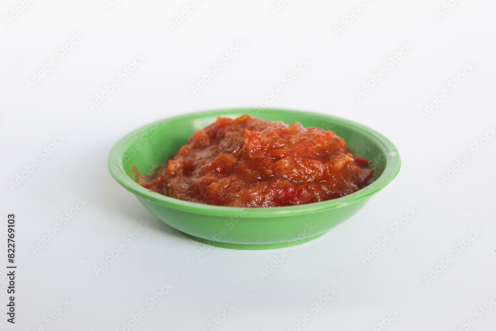 Portrait of tomato chili sauce in a green bowl isolated on a white background. Portrait of tomato chili sauce in a green bowl isolated on a white background.