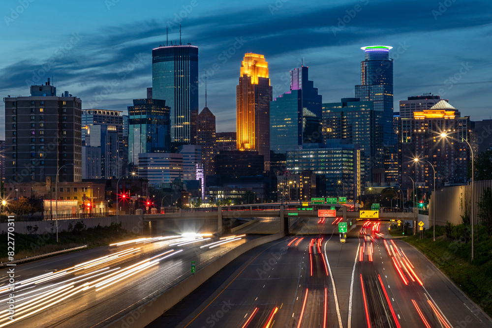 Obraz premium The lights of the Minneapolis Skyline come alive in Minnesota as daylight fades and a busy city adds vibrance to this growing Midwest city