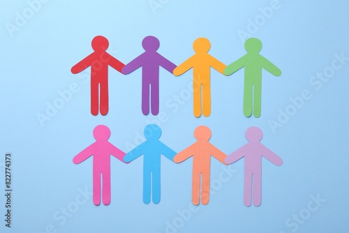 Equality concept. Different human figures on light blue background, flat lay