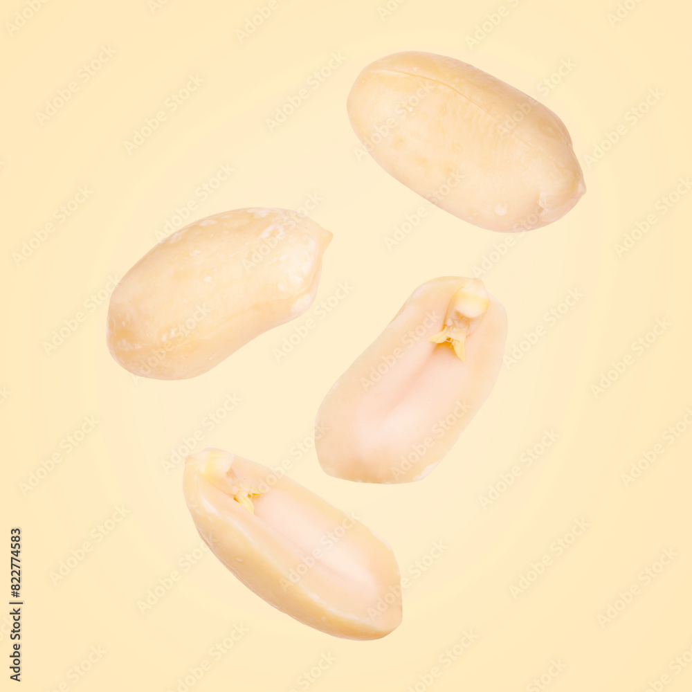 Many peanuts in air on beige background Many peanuts in air on beige background