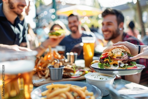 A diverse group of friends dine at an outdoor cafe  enjoying burgers and drinking beer together.