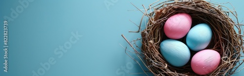 Frohe Ostern Grusskarte Banner mit pastel pink und blaue bemalte Ostereier in Nest auf blauem Tisch Hintergrund - Draufsicht photo