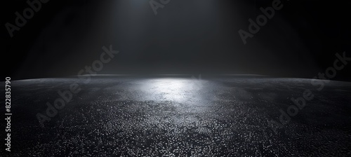 Abstract dark background with glowing light on asphalt floor