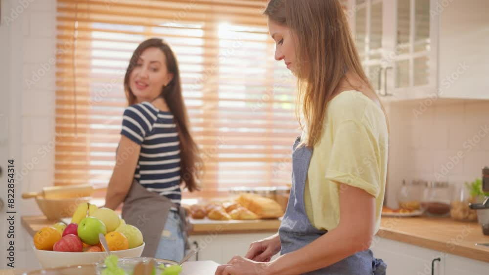 Caucasian young lesbian couple spend time together in kitchen at home. Caucasian young lesbian couple spend time together in kitchen at home.
