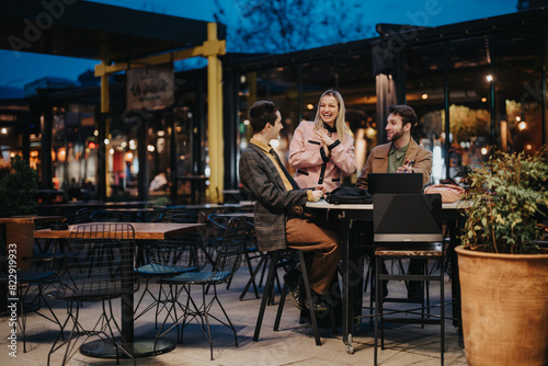 Three business professionals engaging in a lively discussion about project strategies and solutions at an outdoor cafe setting.