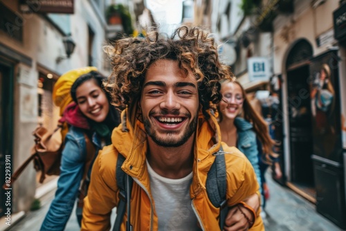 Cheerful young man with curly hair and friends on the background