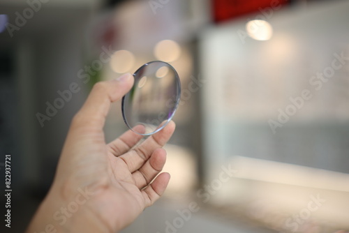 close up of a person holding a magnifying glass, hand holding glasses lens in optical store  photo