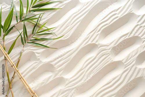 A white sand background with gentle ripples and a few thin bamboo stalks arranged diagonally photo