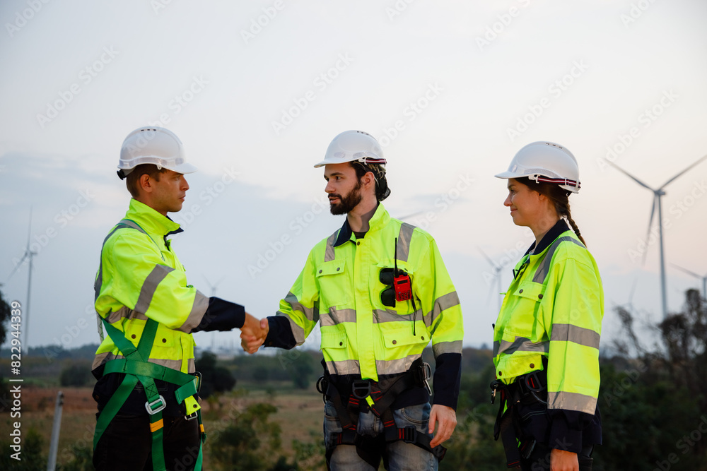 Team engineer wearing safety uniform shake hand discussed plan about renewable energy at station energy power wind. technology protect environment reduce global warming problems. Team engineer wearing safety uniform shake hand discussed plan about renewable energy at station energy power wind. technology protect environment reduce global warming problems.