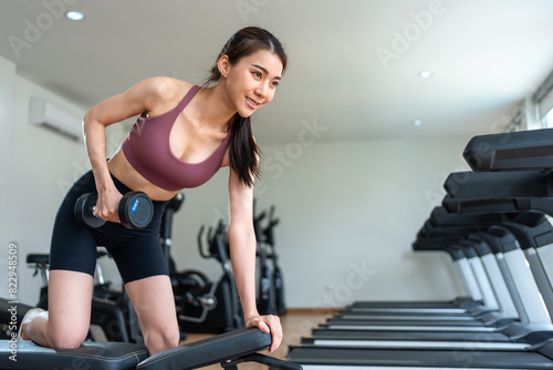 Asian young sport woman exercising to building muscle in gym stadium.