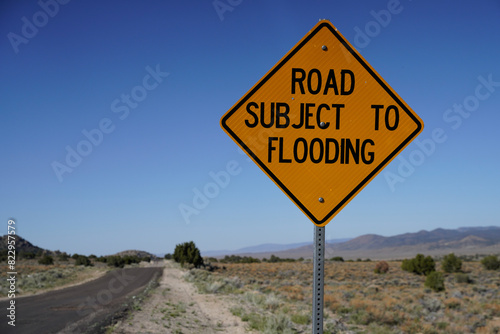 Road Subject to Flooding sign in desert. Blue sky.