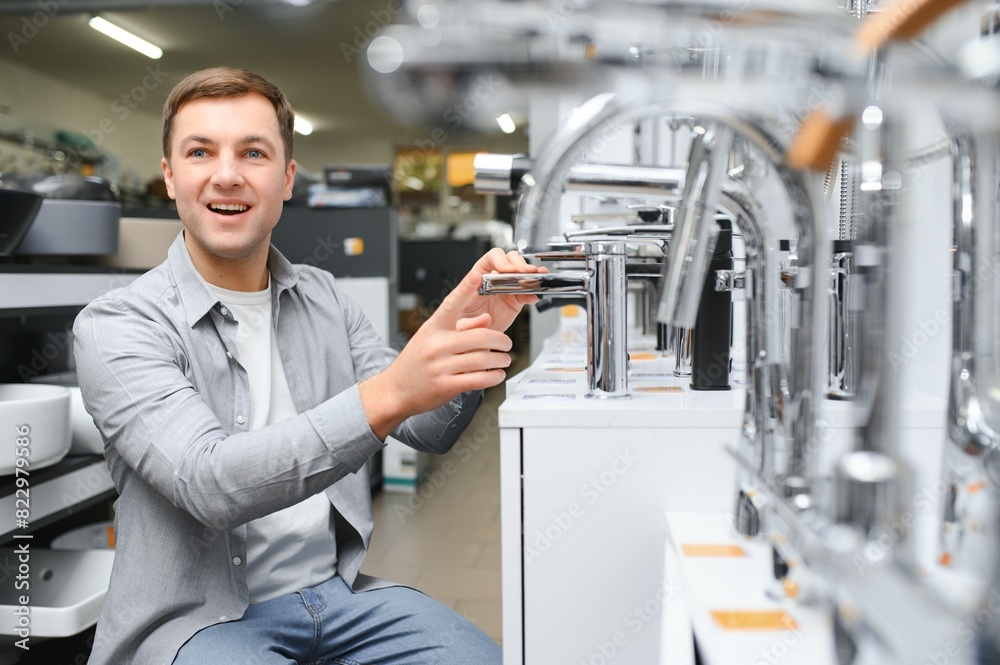 man chooses a bathroom faucet in a construction supermarket, plumbing repairs in the house man chooses a bathroom faucet in a construction supermarket, plumbing repairs in the house
