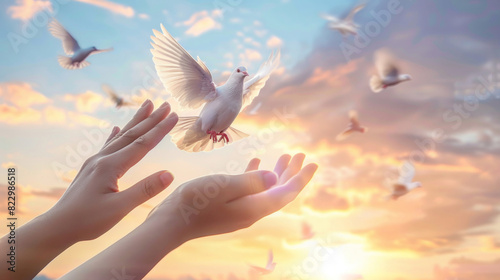 Hands open, releasing doves at sunset, symbolizing freedom and hope as the birds take flight into the sky. © Duka Mer
