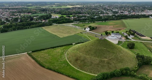 Lion's Mound Monument, Battle of Waterloo, Braine-l'Alleud, Belgium, June 2022. Drone pulls away from Butte du Lion monument across battlefield revealing la Haiye Sainte farm house. photo