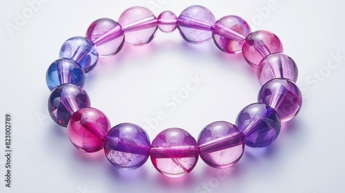 Top view, pink and purple bracelet on a white background, isolated and well-lit with studio lighting, perfect for jewelry display © Paul