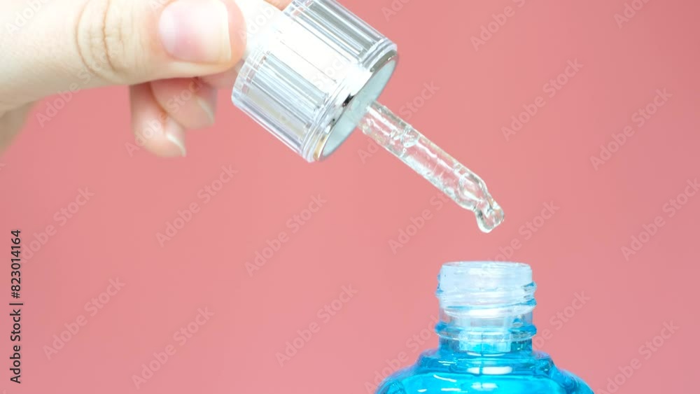 Bottle with serum and pipette on pink background close-up. Bottle with serum and pipette on pink background close-up.