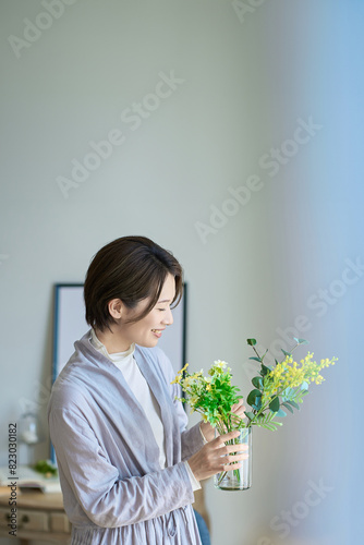 花を飾った花瓶を持つ女性
