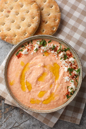 Spicy Greek Feta Dip Tirokafteri with added garlic, bell pepper, yogurt and olive oil closeup on the bowl on the table. Vertical top view from above photo