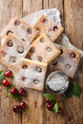 Bublanina pie Czech Fruit Sheet Cake closeup on the parchment on the wooden table. Vertical top view from above photo