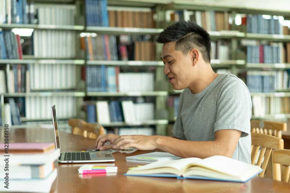 male asian student studying and reading book in library male asian student studying and reading book in library