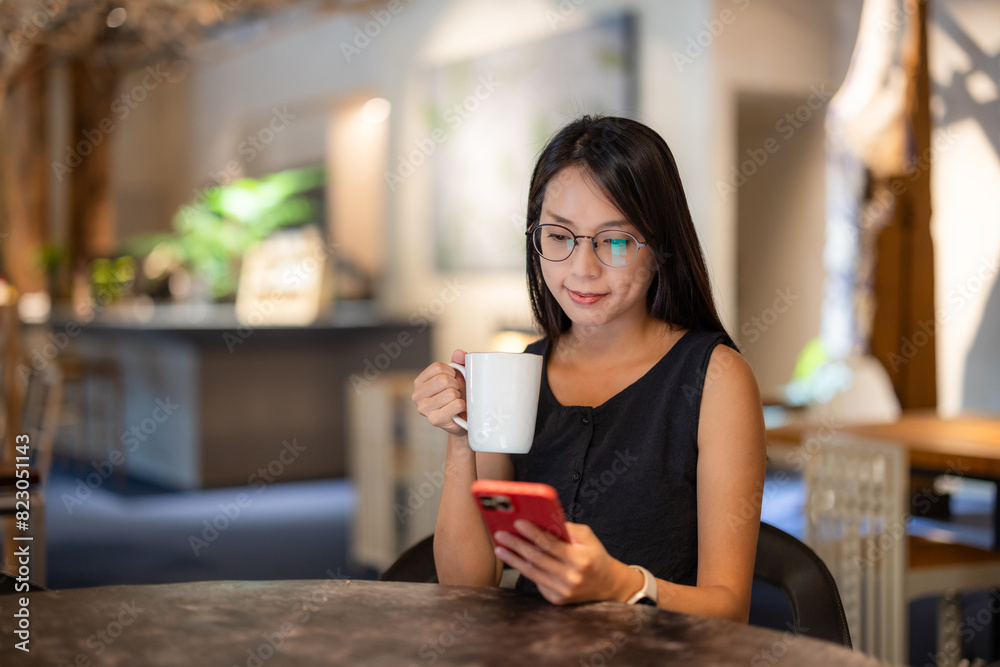 Woman look at the mobile phone in coffee shop Woman look at the mobile phone in coffee shop