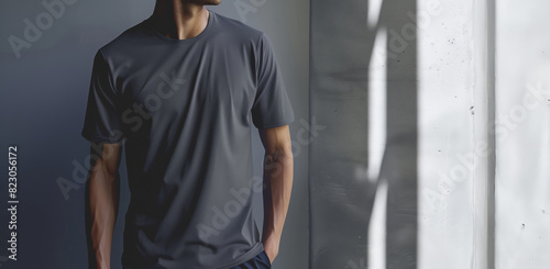 Man Standing in Sunlit Room Wearing a Grey T-Shirt with Hands in Pockets, Mockup