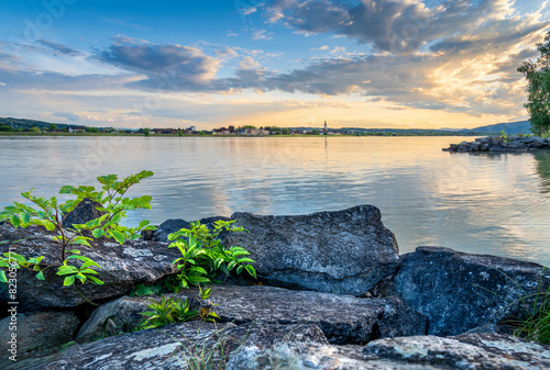 Sunset on the Danube river in Austria with a dominant rock formation at the fore ground and beautiful cloudy sky