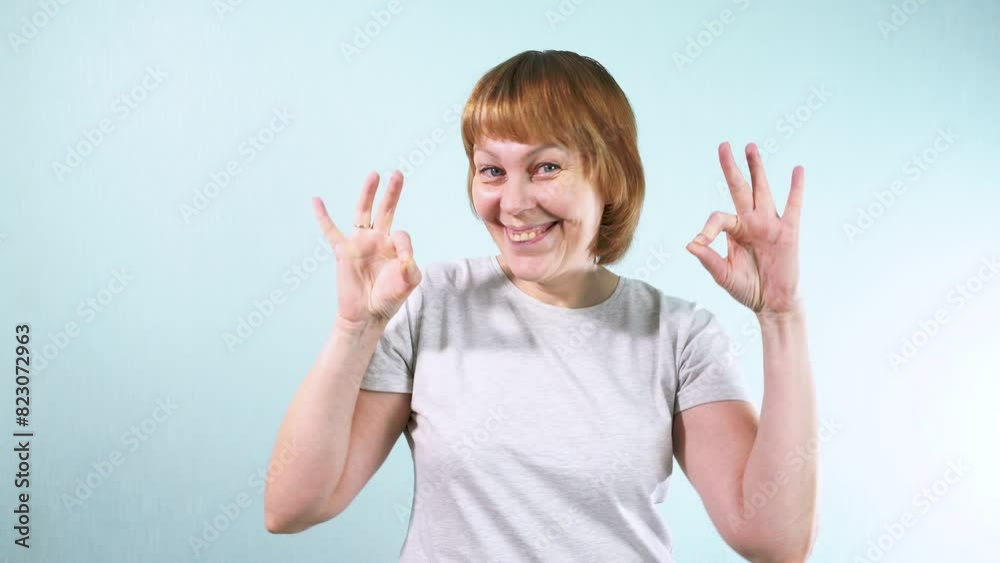 A young woman looks confidently into the camera, smiling brightly and making the 'Ok' gesture with her fingers. Concept of luck and positive mood.
A young woman looks confidently into the camera, smiling brightly and making the 'Ok' gesture with her fingers. Concept of luck and positive mood.
