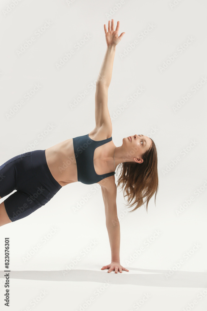 Young woman practicing stretching yoga positions, wellbeing and self care concept Young woman practicing stretching yoga positions, wellbeing and self care concept