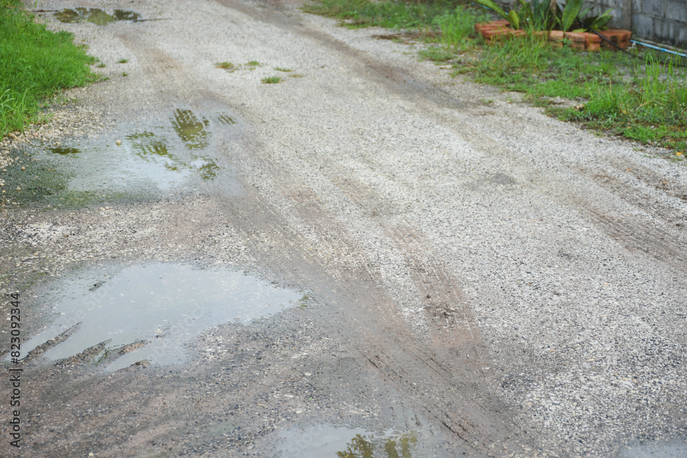 The road is wet with rainwater, has holes and is damaged. The road is wet with rainwater, has holes and is damaged.