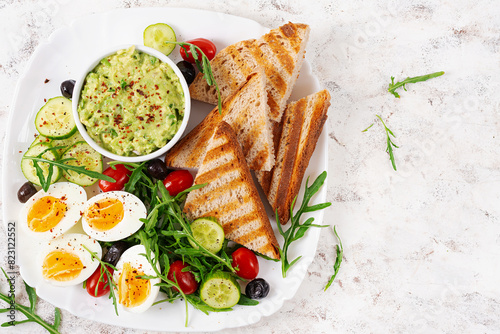 Healthy breakfast. Boiled egg, guacamole, toast and fresh salad. Top view, above