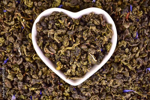 A heart-shaped plate on a background of green tea.
