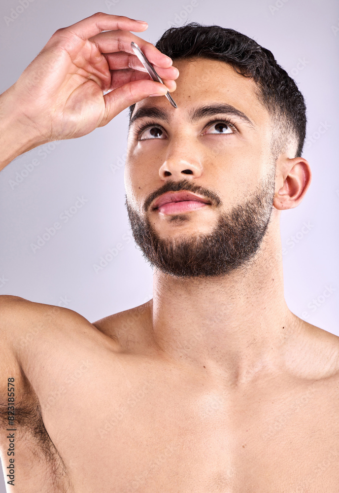 Obraz premium Face, self care and tweezers with a man model plucking eyebrows in studio background, hair removal or trim. Skincare, wellness and beauty routine for grooming, hygiene and cosmetics for cleaning skin