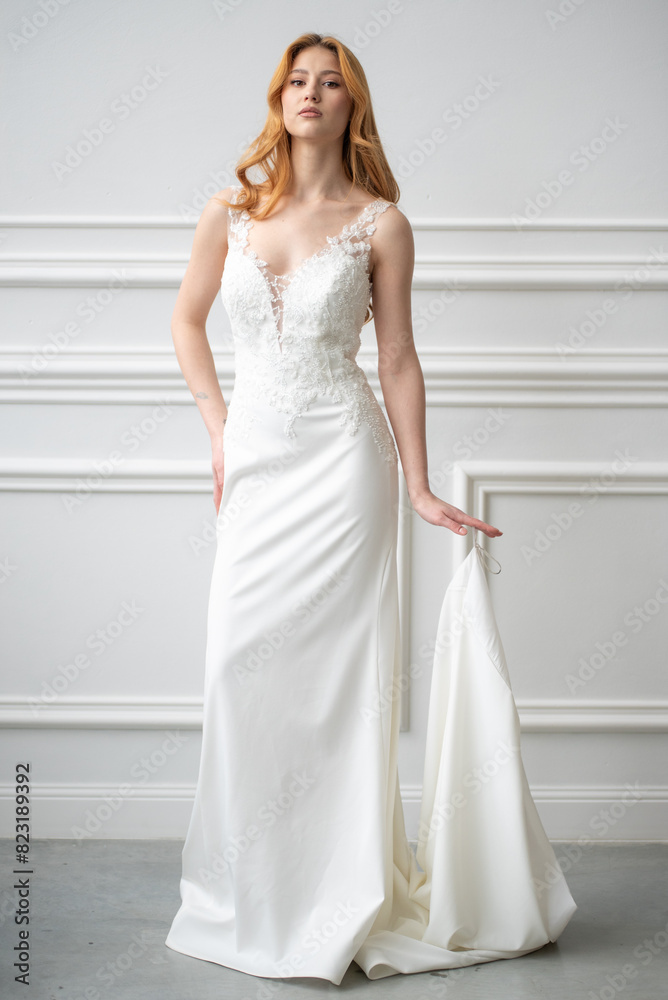 Beautiful young woman bride in fashion wedding dress in white interior Beautiful young woman bride in fashion wedding dress in white interior