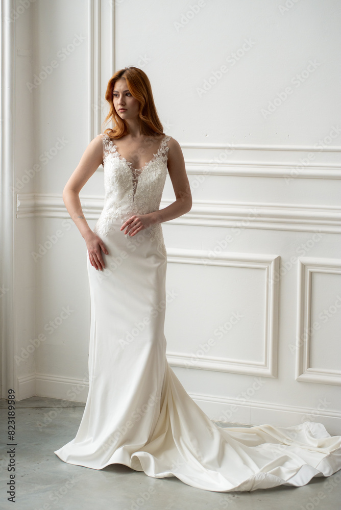 Beautiful young woman bride in fashion wedding dress in white interior