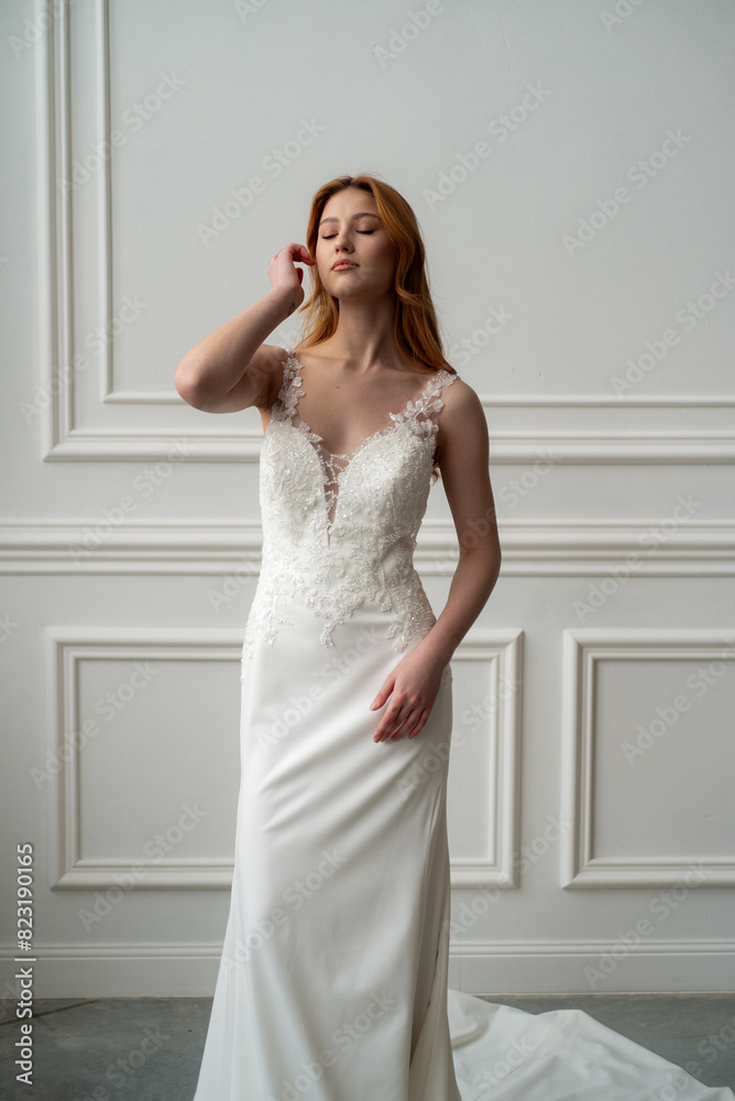 Beautiful young woman bride in fashion wedding dress in white interior Beautiful young woman bride in fashion wedding dress in white interior
