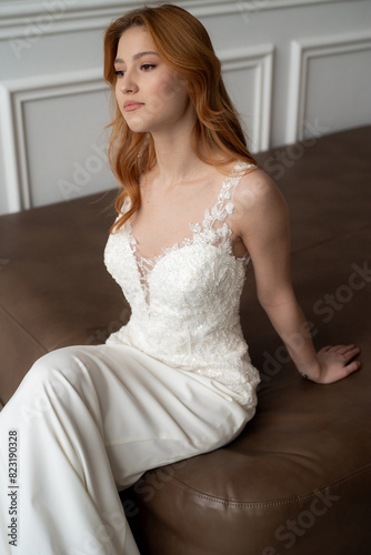 Beautiful young woman bride in fashion wedding dress in white interior