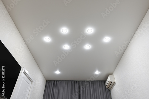 Stretch ceiling in the bedroom with built-in lighting. photo