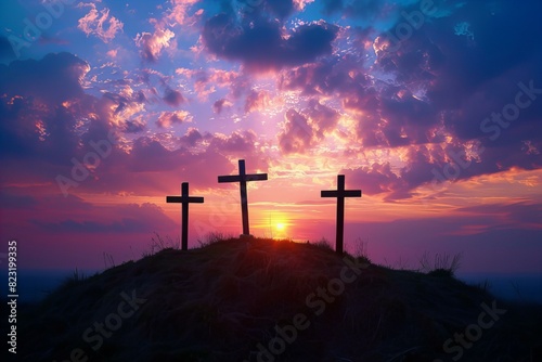 Three crosses on hill with sunset in background