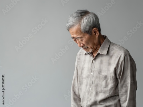 Beige background sad Asian man. Portrait of older mid-aged person beautiful bad mood expression boy Isolated on Background depression anxiety fear burn out health issue problem