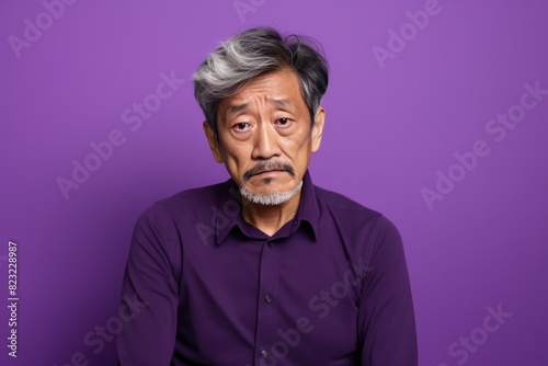 Purple background sad Asian man. Portrait of older mid-aged person beautiful bad mood expression boy Isolated on Background depression anxiety fear burn out health issue © Zickert