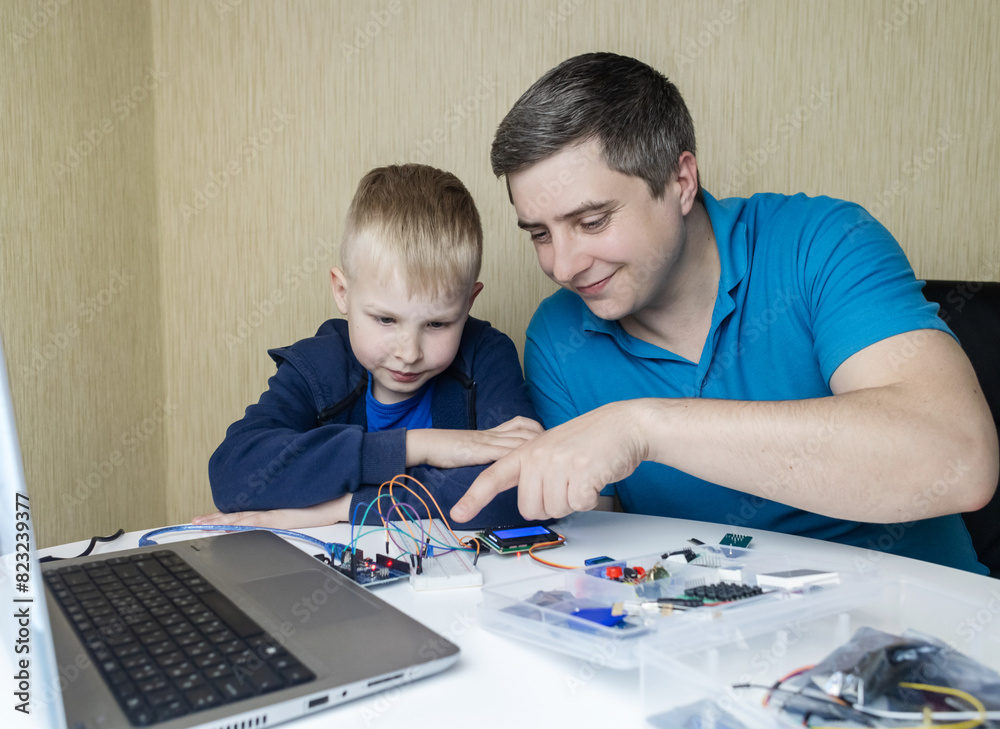 Programming for children. A teacher teaches a child at a robotics and IT school. Boy learning to code control board Programming for children. A teacher teaches a child at a robotics and IT school. Boy learning to code control board