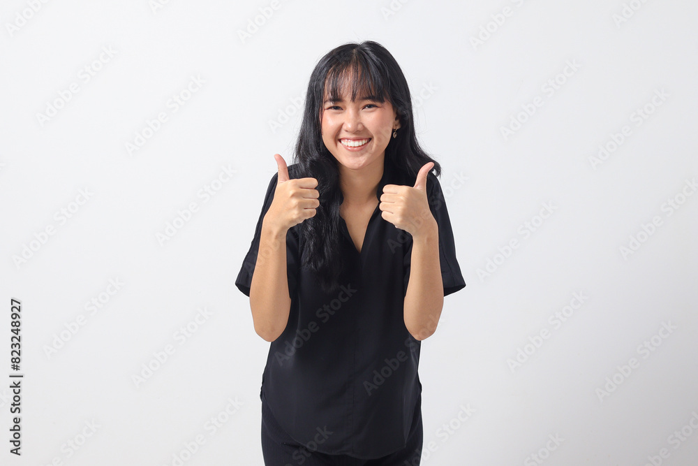Portrait of attractive Asian woman in casual shirt making thumb up hand gesture, saying good job. Businesswoman concept. Isolated image on white background Portrait of attractive Asian woman in casual shirt making thumb up hand gesture, saying good job. Businesswoman concept. Isolated image on white background
