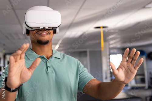 A biracial male physical therapist wearing virtual reality headset at gym rehabilitation center, exp photo