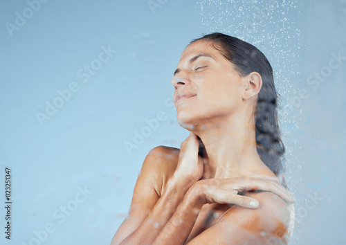 Woman, shower and calm in studio for hygiene with organic, eco friendly cosmetic and daily routine. Girl, isolated and blue background with self care, water and peace with eyes closed and mock up.